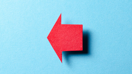Poster - Red blank paper cardboard arrow direction sign with shadow and copy space for text on blue background, flat lay top view pointing symbol conceptual message backdrop