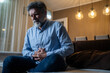 © Nenad - Mature man suffering from strong abdominal pain while sitting on sofa in living room during evening hours