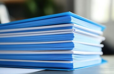 Poster - A close-up image showing a stack of blue folders or file binders on a desk.