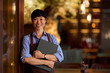 © bnenin - Smiling Restaurant Employee Posing With Menu Folder in Modern Ambiance