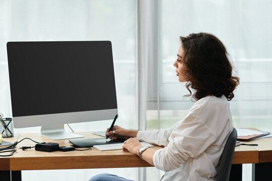 Creative freelancer retouching images at home with her graphic tablet