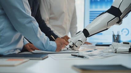Poster - An engaging scene of collaboration in a modern office where human hands and a robot arm work together over documents, reflecting the future of innovative teamwork.Noogenesis