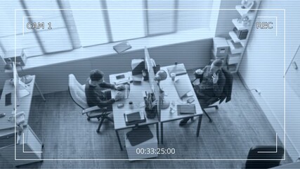 Wall Mural - Security camera footage of office employee typing on laptop while male colleague talking on phone call working at shared desk with privacy panel in contemporary workspace