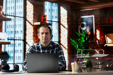 Poster - Man seated at home office desk using laptop, checking emails displayed on screen, reading messages in inbox, composing and sending replies, managing electronic correspondence, organizing email folders
