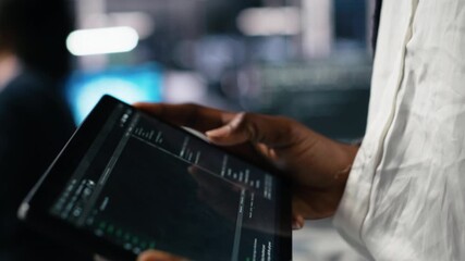 Poster - Close up of data center software developer using tablet to review code for automation scripts. Server hub IT specialist using device, monitoring error logs for debugging processes, camera A
