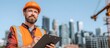 © VeloonaP - A Smiling construction middle-aged worker wearing a yellow vest standing supervisor holding clipboard at building site for Labor day concept.