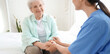 © Pixel-Shot - Physical therapist with senior woman holding hands in bedroom