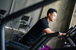 © Huyn - Young man exercising at gym during daytime, focusing on cardio equipment and maintaining fitness routine for health
