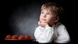 © BOJOShop - Thoughtful young boy in white shirt with round objects on plate child thinking