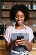 © Frame Vista - Happy african american woman using smartphone at cafe coffee shop barista apron work