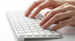 © mumtaz - Close-up of hands typing on a sleek white computer keyboard for work or study in a modern office or home workspace environment perfect for technology and productivity themes