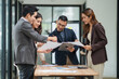 © aekachai - Group of business people are standing in a meeting presenting their work at the office.