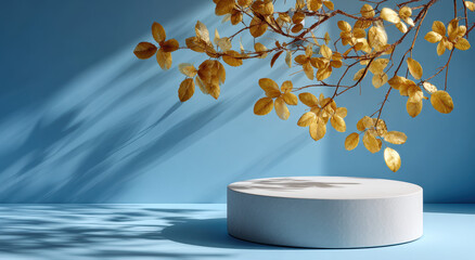 Poster - Golden leaves casting shadows over white podium against blue background create serene and elegant scene