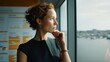 © Image4u - Young woman thinking by window with city view, calm and focused