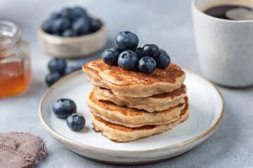Wall Mural - Stack of oat pancakes with blueberries on a plate, closeup view