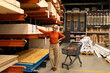 © Ivan Traimak - Woman shopping in a home improvement store, exploring materials and making selections in a vibrant retail environment