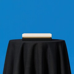 Poster - A minimalist, off-white rectangular box rests atop a sleek black base, which sits on a dark circular table draped in black fabric against a vibrant blue backdrop