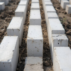 Poster - White bricks are neatly arranged in a row at a construction site, symbolizing building materials, structural foundation.