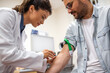 © Graphicroyalty - Female doctor prepares to draw blood from male patient. The patient's arm is secured with a tourniquet, and the doctor is focused on the procedure.