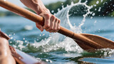 A close-up photograph of a hand holding a wooden paddle immersed in water. The paddle creates splashes, symbolizing active movement. A body of water and washed-out shoreline are visible in the backgro