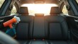 © Patcharin - Detailing a vehicle interior, applying protective coating to leather, maintaining a clean car back seat, using spray applicator