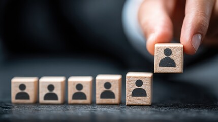 Poster - Person placing a wooden block on a table signifying collaboration and teamwork in an organizational environment