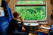 © Iryna - Teen boy drinking from yellow cup during train ride