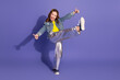 © deagreez - Cheerful young girl wearing trendy outfit and posing with energetic gestures against a purple background