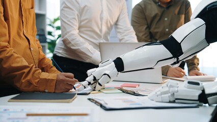 Poster - A futuristic scene shows a human interacting with a robotic arm in a modern office, exemplifying the integration of technology and teamwork in today's workspace.Noogenesis