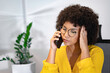 © UP3D STUDIO - Young Black woman in yellow shirt feeling stressed during a phone call in home office. Concept of customer service, work pressure, frustration, or business conflict.