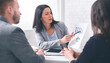 © Prostock-studio - Professional woman broker giving presentation to young couple in her office, showing graphs to explain information to them