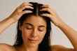 © Татьяна Евдокимова - Woman gently massaging her scalp while applying nourishing hair oil, enhancing relaxation and promoting healthy hair growth