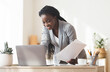 © Prostock-studio - Successful Project. Smiling Afro Business Lady Working With Papers And Laptop In Modern Office, Free Space