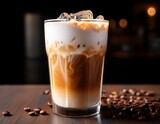 a clear glass filled with a creamy iced latte topped with a thin milk foam and subtle layering condensation droplets appear on the outer surface of the glass