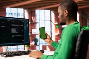 Fototapete - Man at home holding mockup smartphone asks questions to AI LLM chatbot virtual assistant. Person receiving helpful information from artificial intelligence bot, using green screen phone