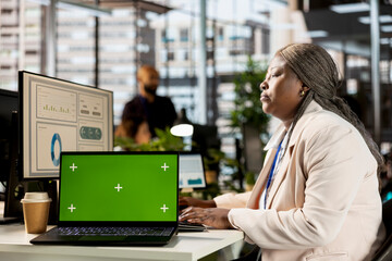 Poster - African american company employee creates business strategy next to isolated screen, analyzing data for a financial report. Global expansion project development, enterprise solutions.