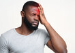 © Prostock-studio - Young man suffering from terrible strong head pain, touching his forehead, photo with red sore zone