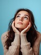 © Mochamad - Thoughtful Young Woman in Beige Sweater, Looking Upward