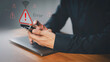 © ParinPIX - Person holding a smartphone with warning icon and a no Wi-Fi signal symbol. Idea for IT security service and digital risk content, a digital error, internet connection failure, malware, data breaches.