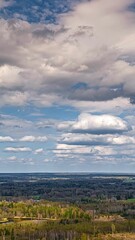 Wall Mural - dramatic cloudy sky over rural forest with moving clouds in drone hyperlapse, vertical