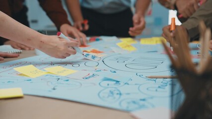 Poster - Engaging brainstorming session with diverse team members actively discussing ideas, using sticky notes, and sketching concepts on a large paper within a creative workspace. SACTR