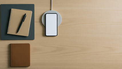 Poster - Desk Essentials: A meticulously arranged desk scene showcasing a sleek mobile phone charging wirelessly, accompanied by a notepad and pen, and a small accessory, all set on a light wooden surface.