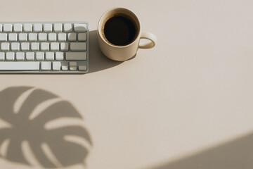 Poster - Morning Office Essentials: A minimalistic, top-down shot captures the tranquil interplay of light and shadow over a keyboard and a steaming mug, invoking a sense of productivity and focus.