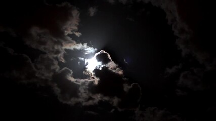 Wall Mural - full moon pierces through thick dramatic clouds in a mysterious night sky
