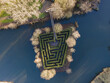 © AmazingAerialAgency - Aerial view of a verdant labyrinth bordered by bare trees in a dark lake, connected by a wooden bridge, creating an intriguing puzzle from above, Amsterdam, North Holland, Netherlands.