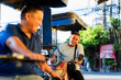 © Mdv Edwards - Filipino tricycle driver laughing and smiling during a lighthearted moment with another driver, showing joy and friendliness in a sunny urban setting.