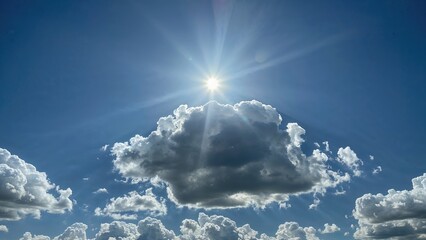 Wall Mural - Illuminating fluffy clouds with sunlight from below. A view of the sky. Stunning sky bathed in sunlight. Clouds floating in a clear blue atmosphere. Puffy clouds set against a bright sky.