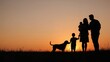 © TheWaterMeloonProjec - Silhouette showing a cheerful family of four plus their pet dog in front of a dusk sky, designed with room for writing