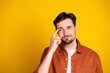 © deagreez - Handsome man making thoughtful gesture with finger on head in casual shirt against a bright yellow background