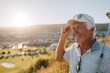 © Mashina - Happy Senior Man Enjoying Golf at Sunset with Beautiful Scenic View of Nature Holding Golf Club and Wearing Stylish Cap and Sunglasses